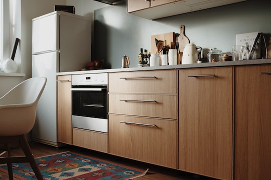 kitchen with light wood cabinets, white fridge and stainless steel oven